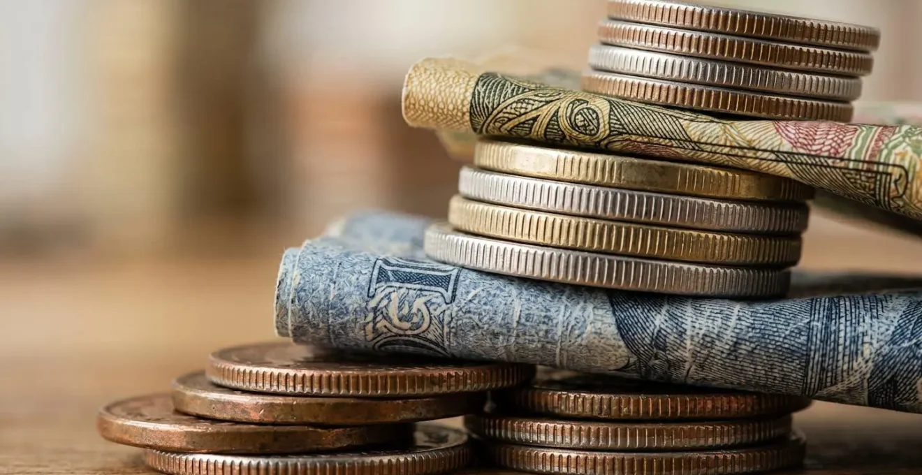 Macro photograph showing layers of coins and currency representing different cost components in inventory valuation