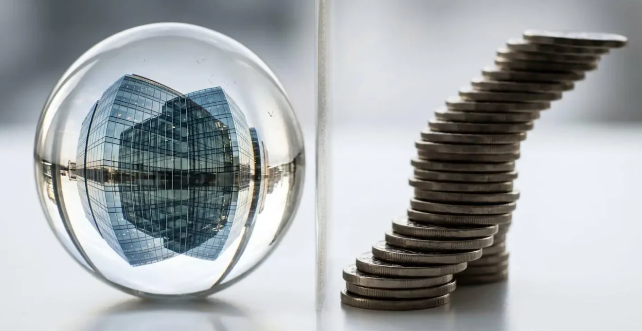 Abstract visualization of property investment through a pension scheme, showing a building reflected in a glass sphere next to stacked coins.